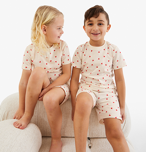 Två barn med pyjamasar med hjärtan på